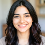 A close-up portrait of a young Latina woman with a bright smile.