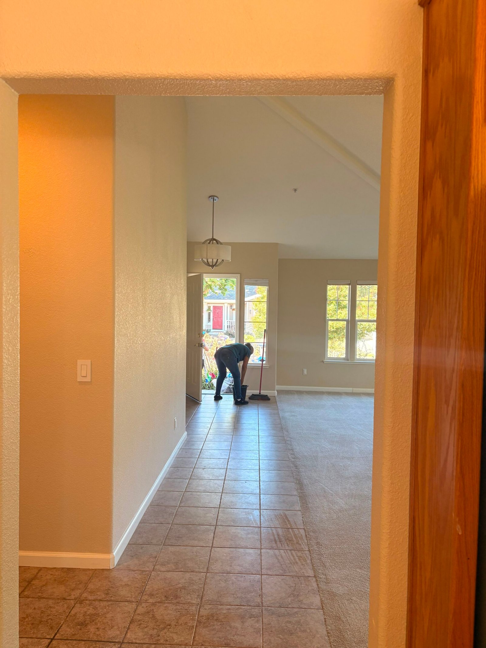 Gloved cleaning professional dusting and polishing a wood console table in a Napa home